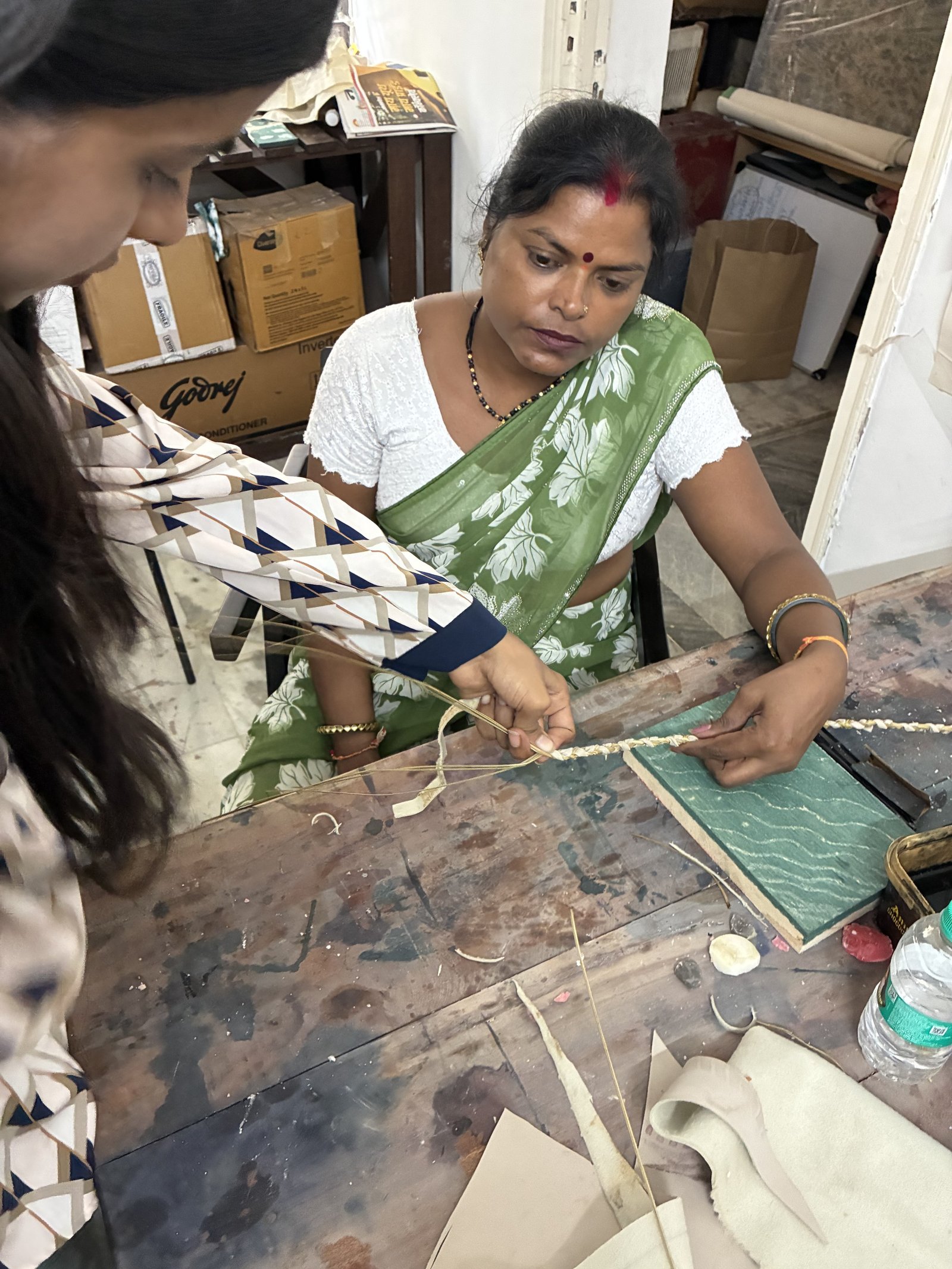Spero woman artisan focused on hand-weaving at workshop table